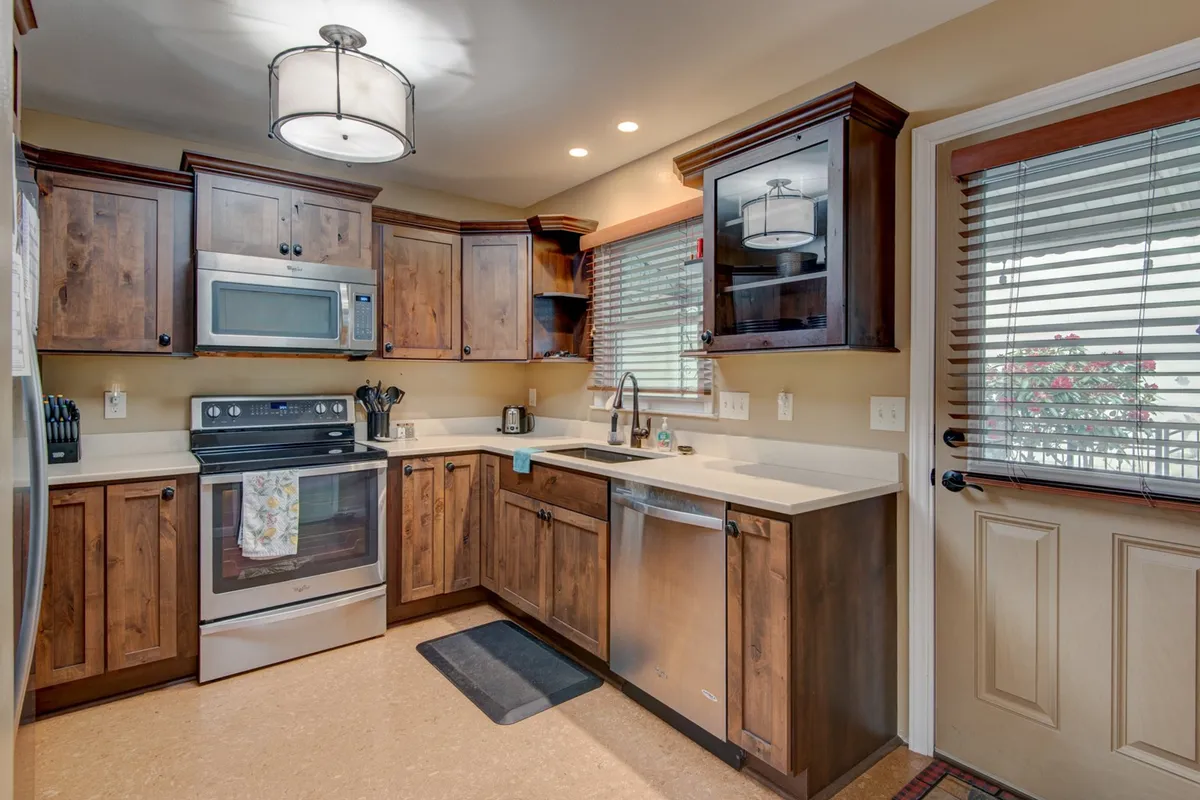 A warm and welcoming kitchen with ample cabinetry, countertops, modern appliances, a window, and a door. The layout is open and functional, designed for cooking, entertaining, and family gatherings.