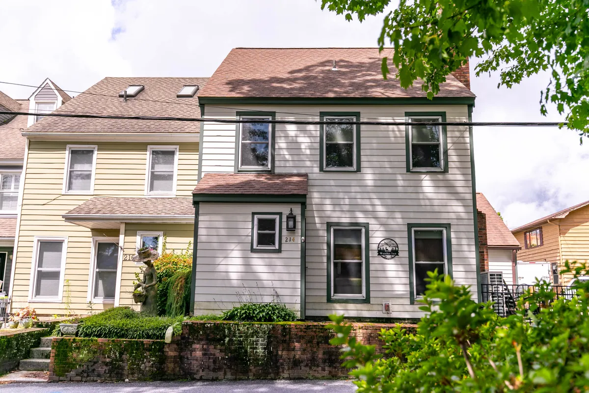 A two-story home with green trim, a welcoming front door, and well-kept landscaping. The image captures a sense of arrival and the property's connection to the neighborhood, setting the scene for easy access to nearby family-friendly attractions.