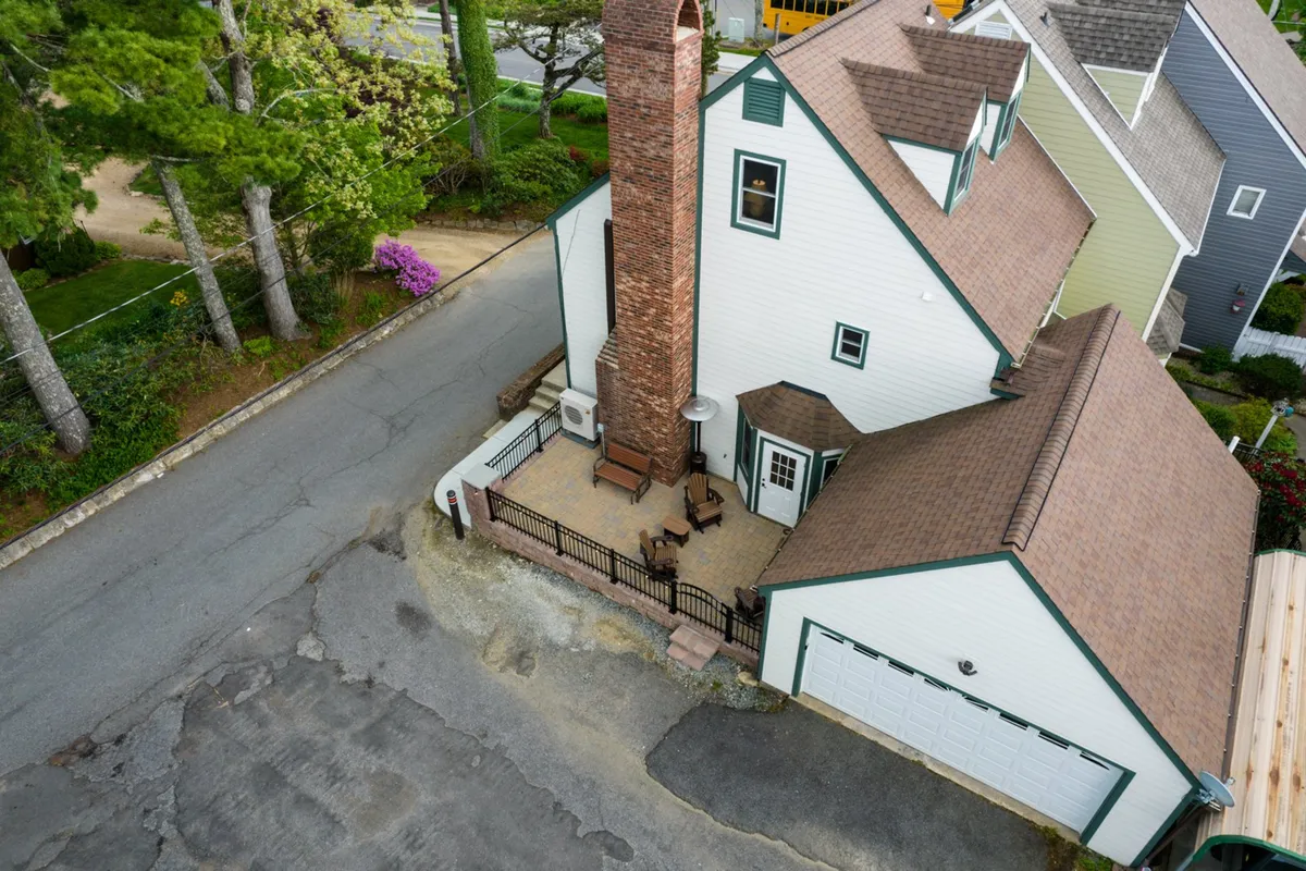 A welcoming fenced patio with a brick chimney, comfortable outdoor seating, and vibrant greenery, offering a tranquil setting for entertaining or quiet moments. The enclosure and garden details reinforce the sense of a special retreat within the city.